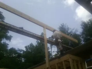 Carpenter setting a ridge beam over a new addition frame — Ice Dam Removal by Roofing Brothers in Bleiblerville
