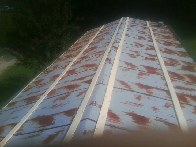 Rusted metal roof panels with new wood purlins before replacement — Storm Damage Roof Repair in Bleiblerville by Roofing Brothers