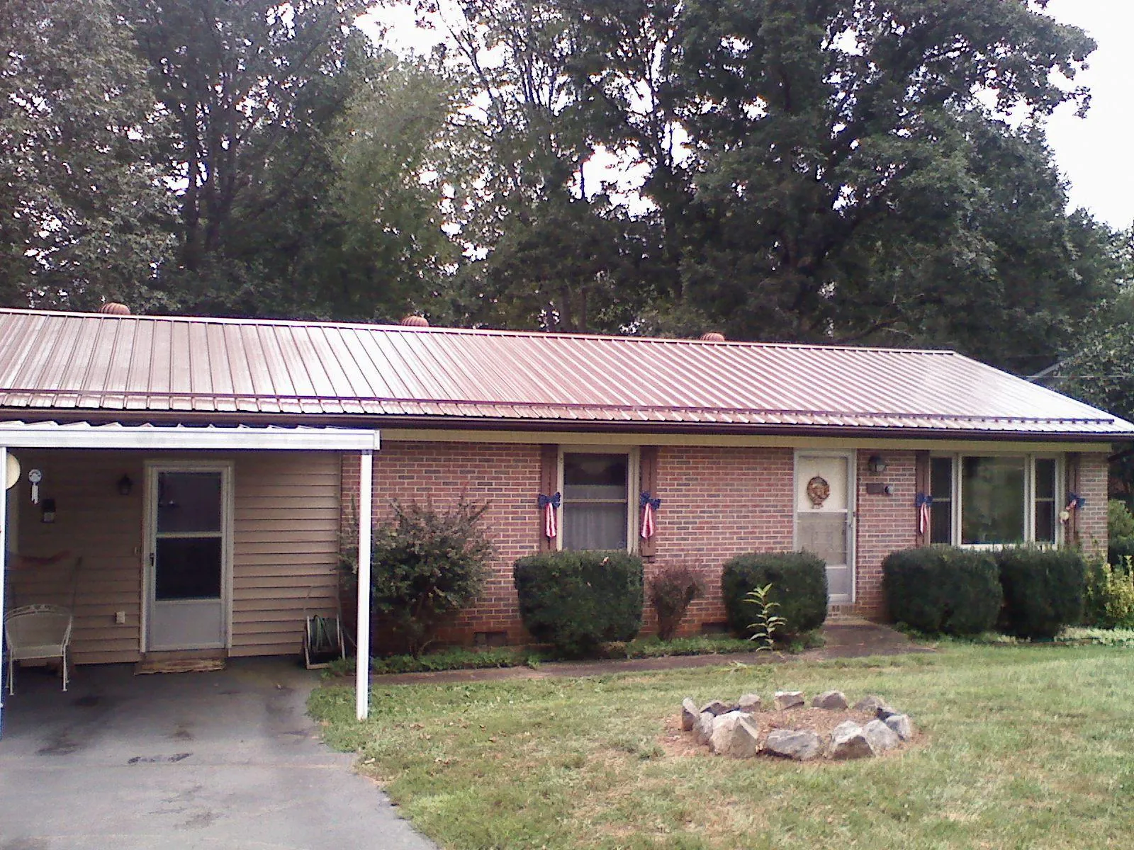 Bronze metal roof and carport on a brick ranch home — Roof Repair work by our crew in Bleiblerville